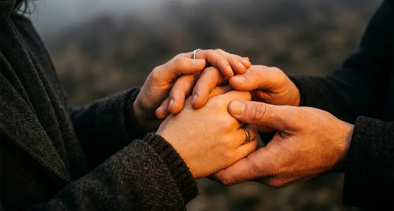 Mãos oferecendo ajuda e acolhimento, superando barreiras religiosas.